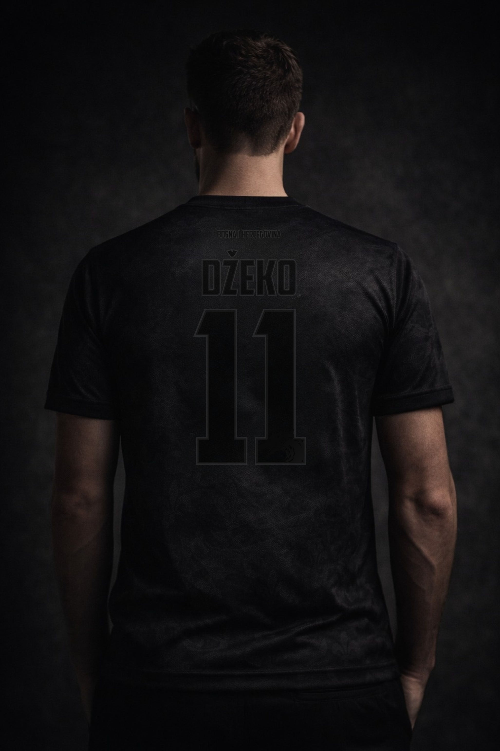 Person wearing a black t-shirt with 'Džeko' and number '11' on the back against a dark background