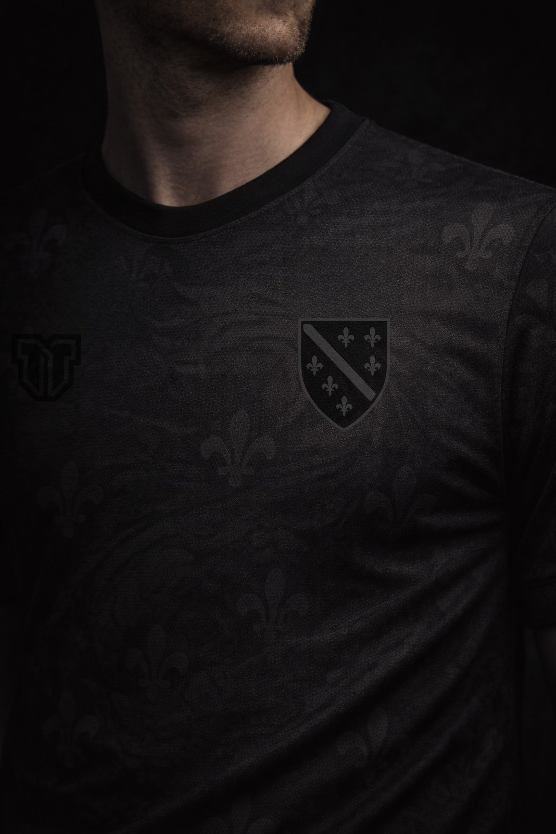 Black t-shirt with a logo on a dark background